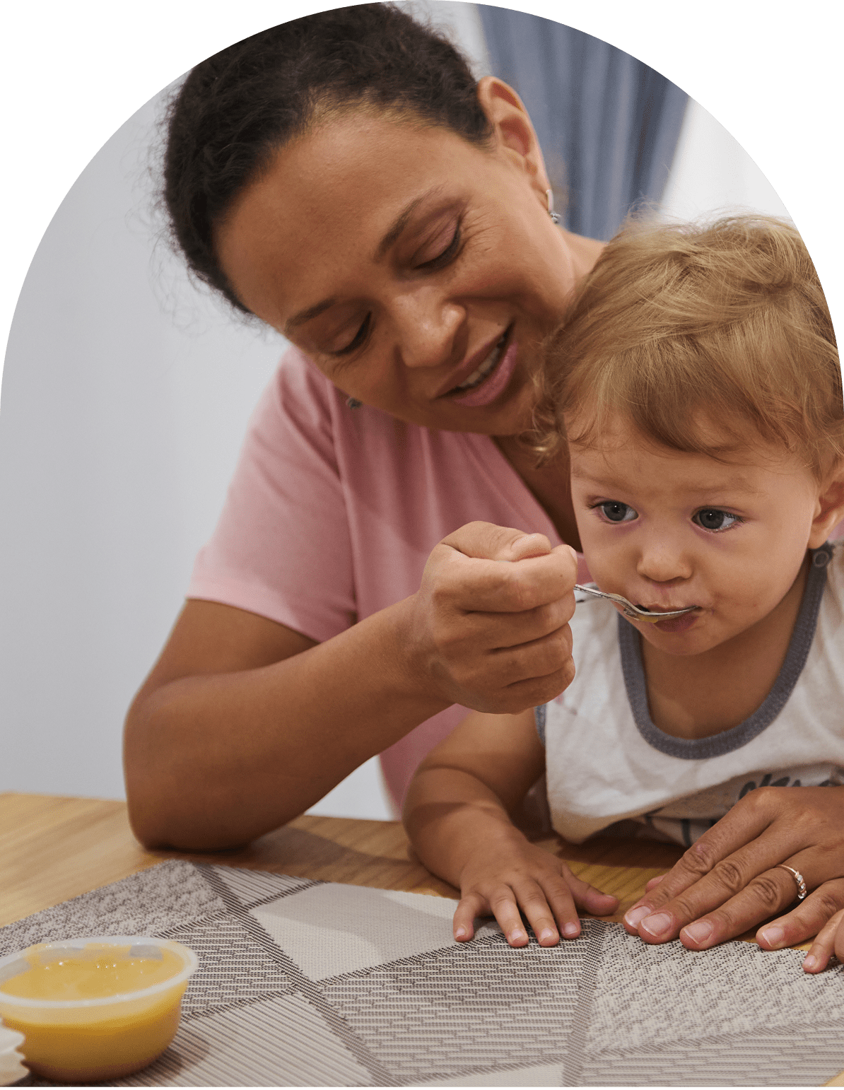 GettyImages-2161932830 (1)-1 Adult feeding a toddler with a spoon.